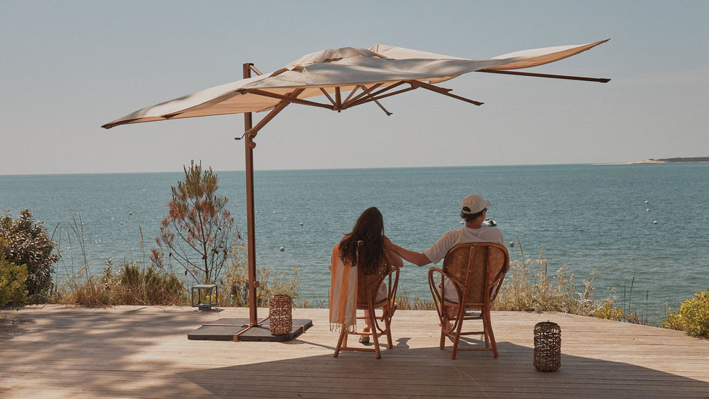 Un couple qui se détend sur leur balcon sous un parasol 