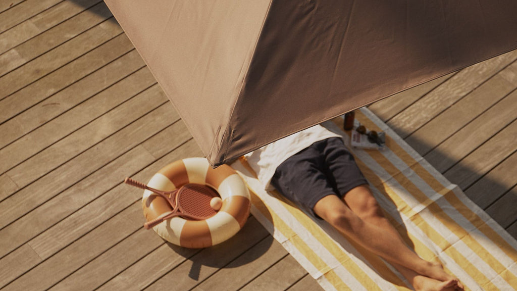 Un homme se reposant sous son parasol 