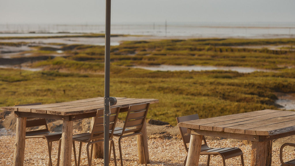 Des tables et chaises de jardin sous un parasol