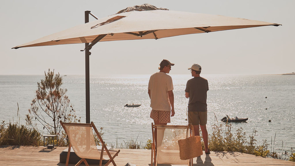 Deux amis discutant sous un parasol de terrasse