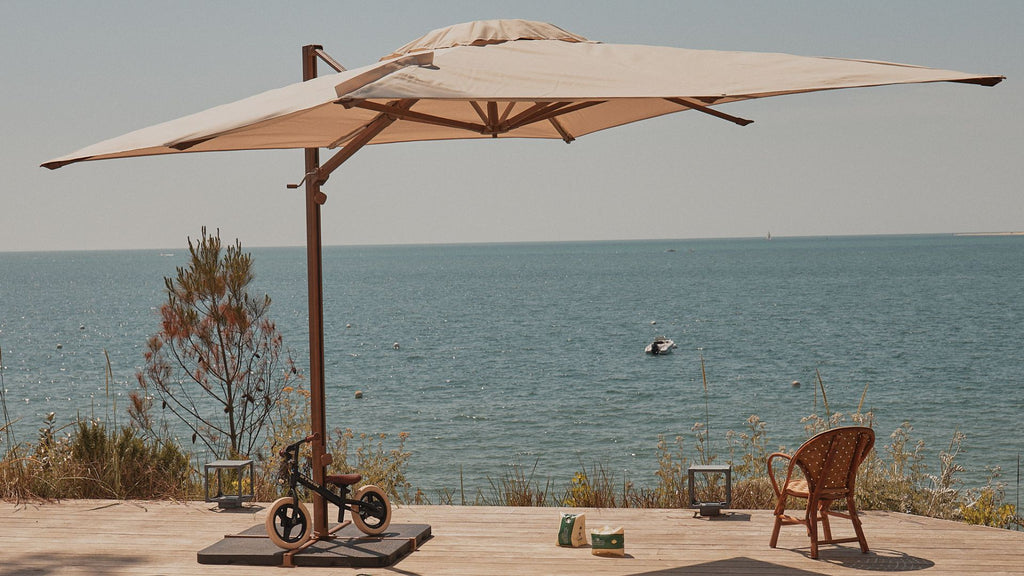 Un parasol déporté sur une terrasse au bord de mer